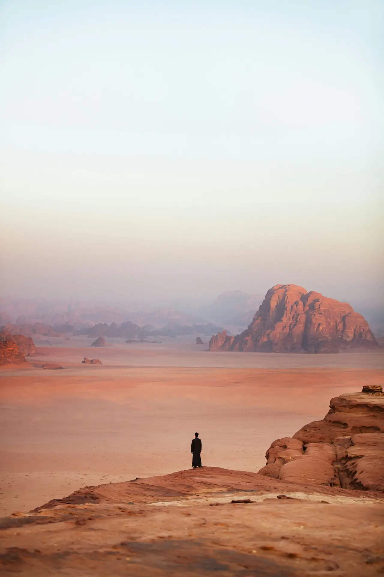 Voyageur contemplant l’immensité d’un désert rocheux aux teintes ocre