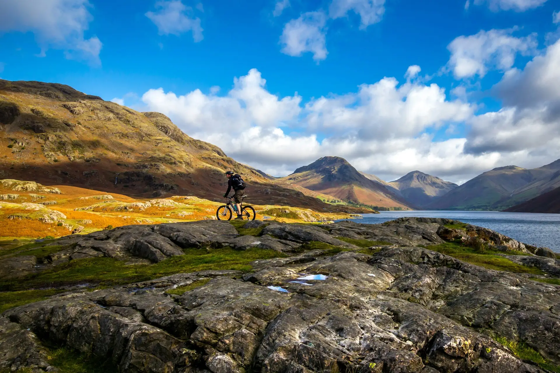 Voyageur à VTT traversant un vaste paysage montagneux