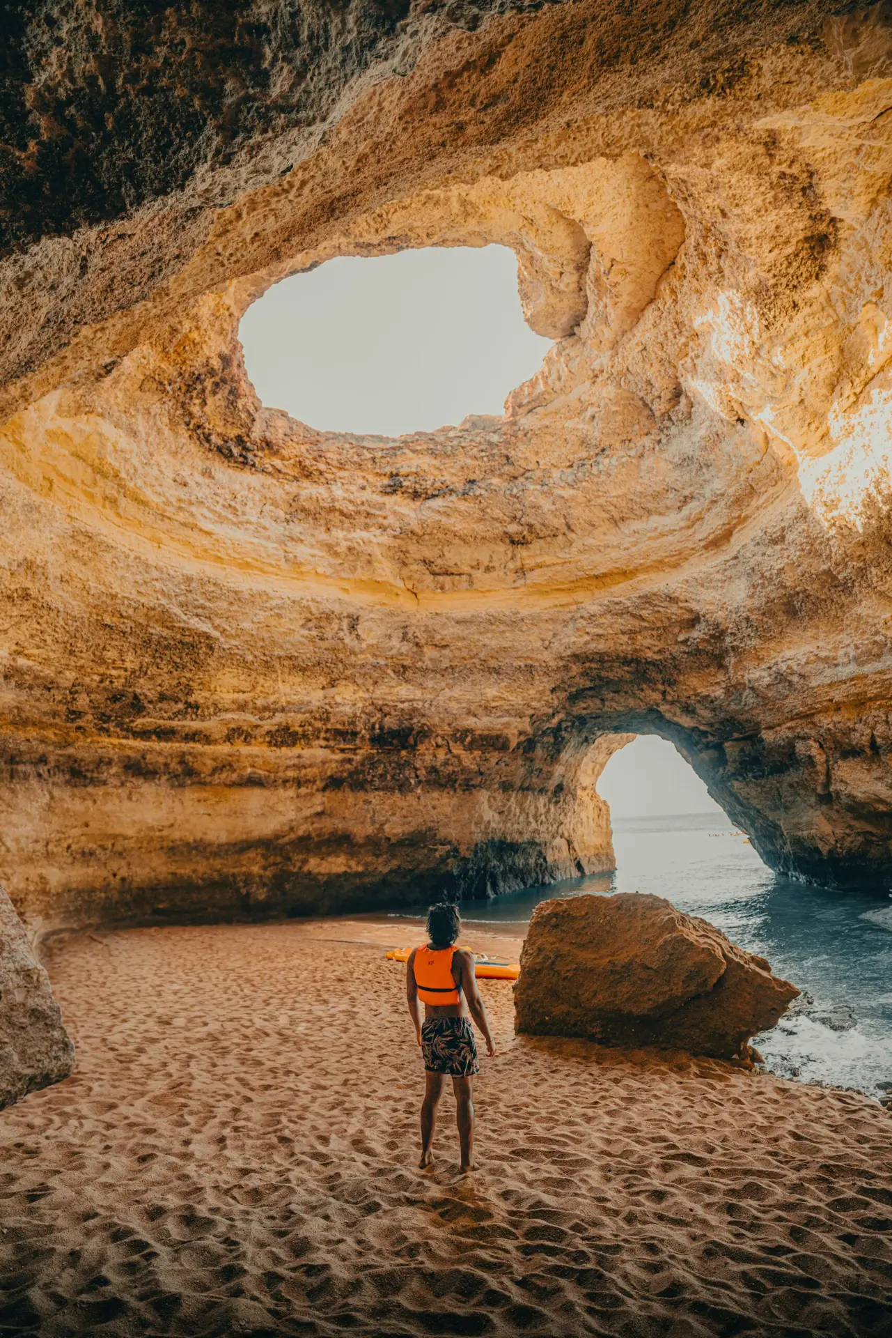 Voyageur face à une grotte marine ouverte sur l’océan au Portugal